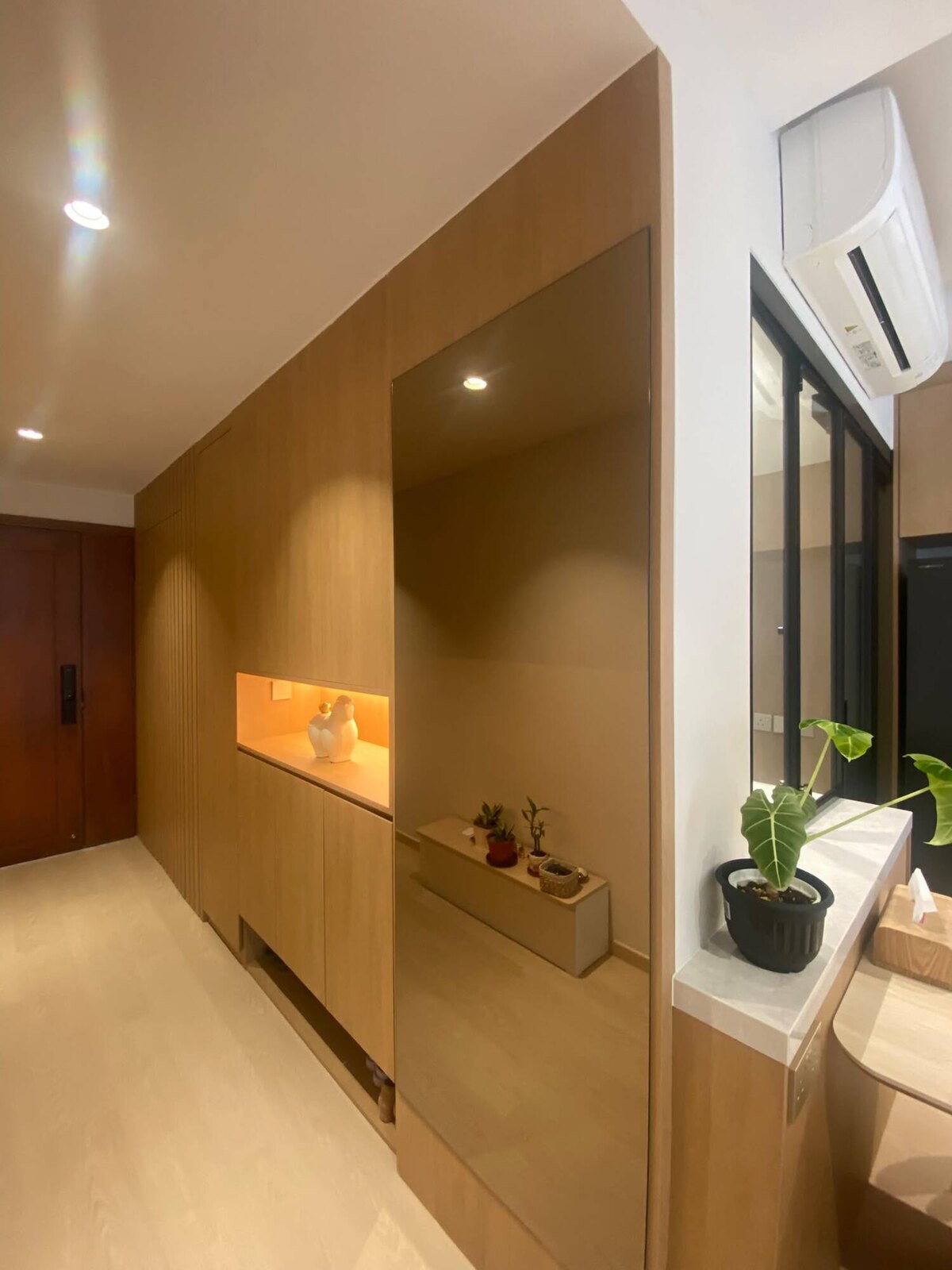 Entry foyer with a back-lit niche and bronze mirror