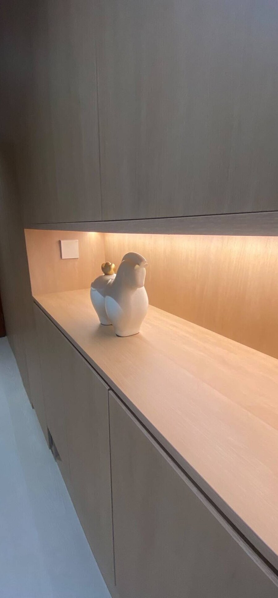 Back-lit oak display niche with a warm LED cove